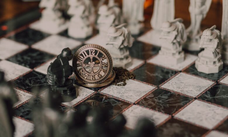 Close-up of a detailed chess set inspired by fantasy themes with a magical vintage clock on the board.