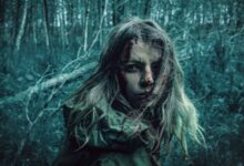 A dramatic portrait of a distressed woman in a dark, eerie forest setting.