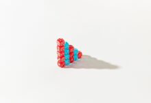 Stacked red and blue dice form a pyramid on a white background, casting a shadow.