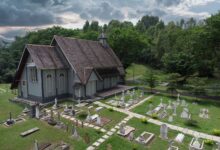 Scenic aerial view of All Saints Church surrounded by lush greenery and cemetery in Taiping, Malaysia.