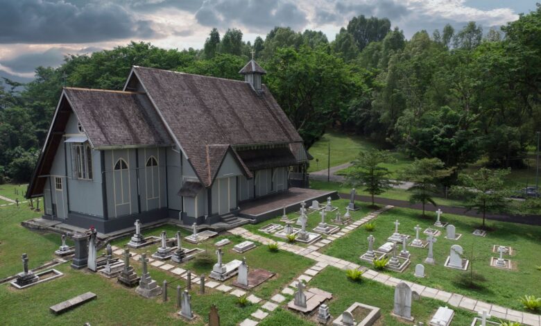Scenic aerial view of All Saints Church surrounded by lush greenery and cemetery in Taiping, Malaysia.