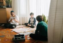 Three boys playing a strategic board game in a cozy indoor setting, emphasizing friendship and fun.