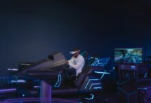 A young man immersed in a virtual reality driving simulation, wearing a VR headset indoors.