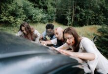 A group of zombies attack a car in a dense forest, creating a chilling, horror-filled scene.