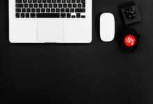 Minimalist flat lay featuring a laptop and shopping items with 50% sale tags.