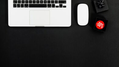 Minimalist flat lay featuring a laptop and shopping items with 50% sale tags.