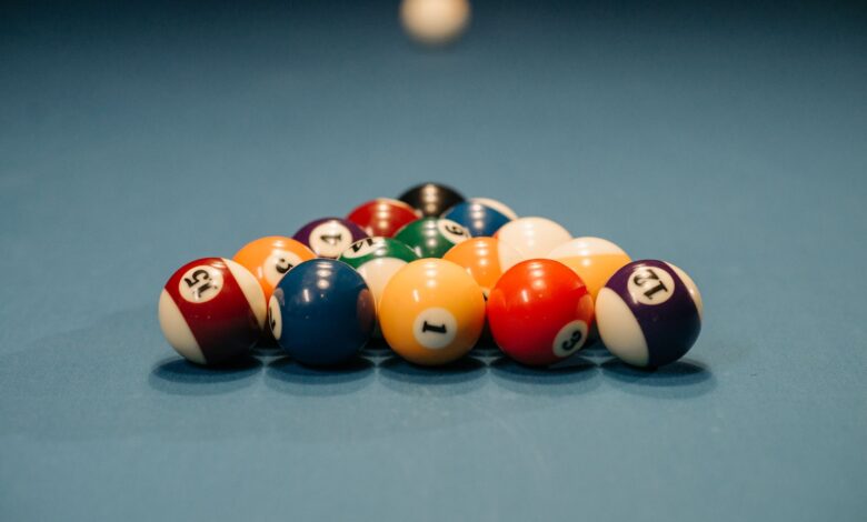 Close-up view of colorful billiard balls arranged for a pool game. Depth of field emphasizes the arrangement.