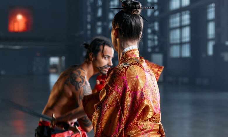 A dramatic scene of martial artists in traditional Japanese attire poised in confrontation within an industrial setting.