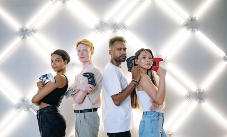 Four diverse friends posing confidently with game controllers against a modern LED backdrop.