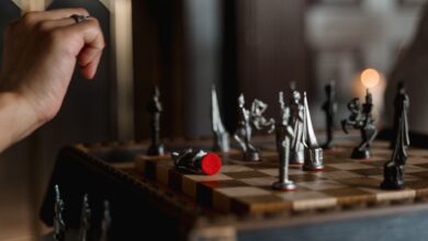 An intense moment captured during a chess game, featuring a poised hand above a detailed chessboard.