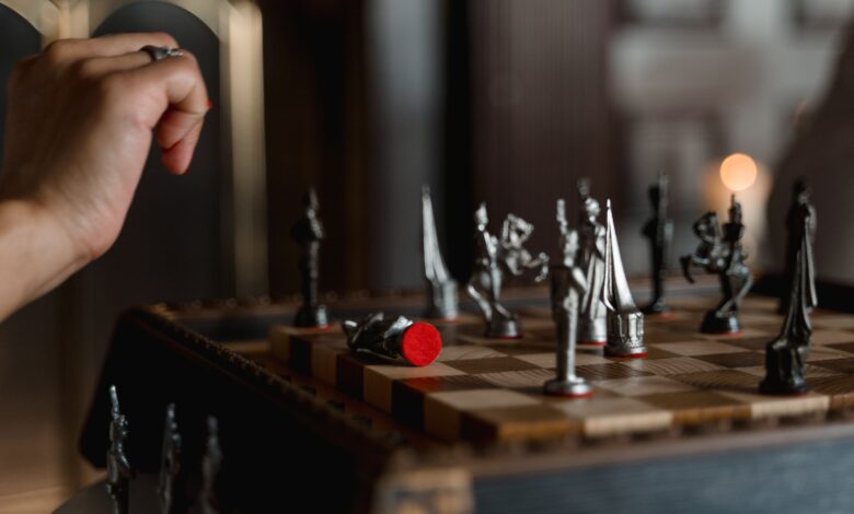 An intense moment captured during a chess game, featuring a poised hand above a detailed chessboard.
