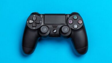 Black game controller against a vibrant blue background, perfect for gaming-themed content.