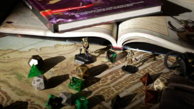 Close-up of tabletop RPG setup with books, dice, and figurines on a map.