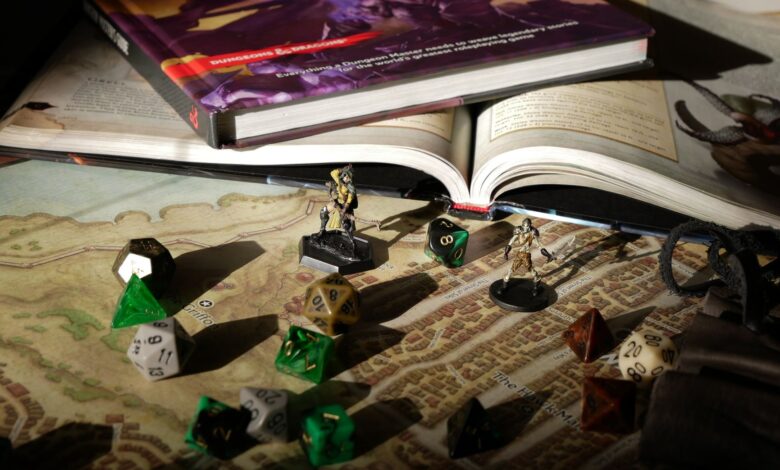 Close-up of tabletop RPG setup with books, dice, and figurines on a map.