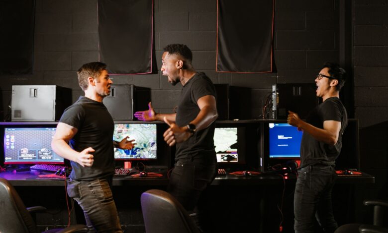 Enthusiastic group of diverse friends celebrating a gaming victory in an esports setting.