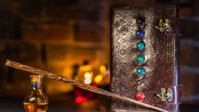 Close-up of a wizard's wand and potion with a magical spell book on a rustic background.