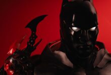 Dramatic portrayal of Batman cosplay against a vivid red backdrop, emphasizing iconic details.