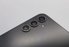 Close-up of a sleek smartphone with triple camera lenses and matte finish.