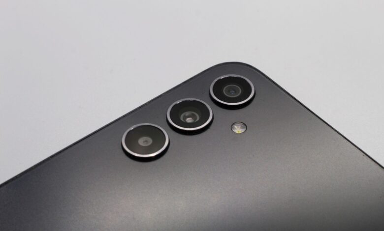 Close-up of a sleek smartphone with triple camera lenses and matte finish.