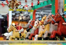 Vibrant carousel of toy horses in an amusement park setting, perfect for family fun themes.
