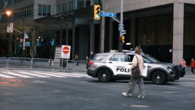 A woman crosses a city street with a Toronto police vehicle nearby.