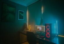 A dimly lit minimalist gaming setup featuring a desktop PC and neon lights.