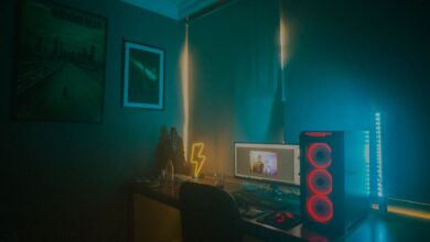 A dimly lit minimalist gaming setup featuring a desktop PC and neon lights.