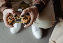 A person playing video games with a vintage-style controller indoors.