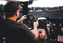 Focused gamer experiencing a detailed driving simulation setup indoors.