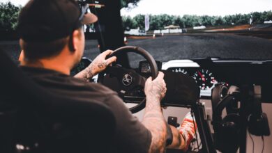 Focused gamer experiencing a detailed driving simulation setup indoors.