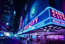 Iconic Radio City Music Hall with neon lights at night in New York City.