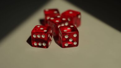 Five red dice with white dots photographed on a neutral background.