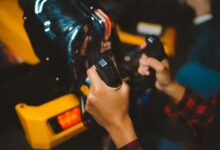 Close-up shot of hands gripping arcade game controllers, showcasing an immersive gaming experience indoors.