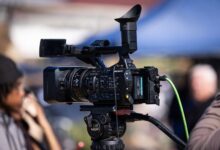 Close-up of a professional video camera set up for filming outdoors, capturing dynamic scenes in natural light.