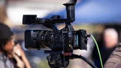 Close-up of a professional video camera set up for filming outdoors, capturing dynamic scenes in natural light.