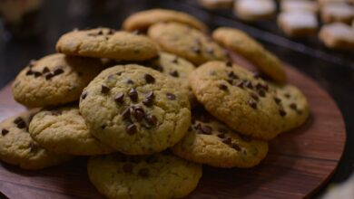 Close-up view of freshly baked chocolate chip cookies on a wooden tray.