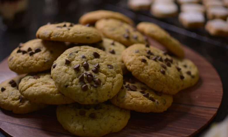 Close-up view of freshly baked chocolate chip cookies on a wooden tray.