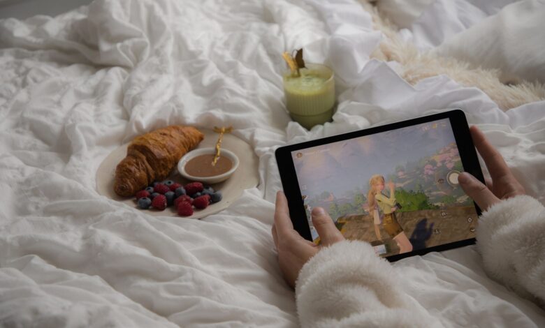 Enjoy a cozy morning in bed with a croissant, berries, matcha latte, and a tablet game.