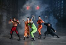 A diverse group of cosplayers posing as game characters indoors, surrounded by smoke.