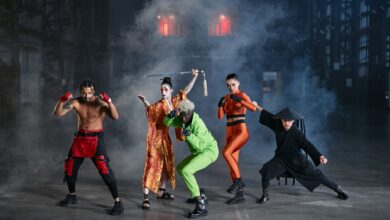 A diverse group of cosplayers posing as game characters indoors, surrounded by smoke.