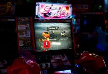 Close-up of an arcade gaming machine screen in a lively amusement center, offering speed racing game options.