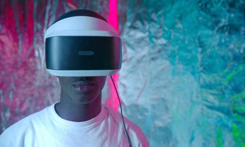 Teen enjoying virtual reality experience with vibrant neon lights.