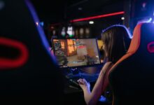 A woman is deeply engaged in playing computer games indoors, highlighting the gaming lifestyle.