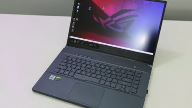 A sleek and modern laptop featuring a black keyboard on a white desk top, showcasing technology and design.