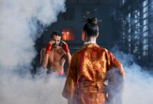 Two martial artists in traditional attire face off in a dramatic, smoke-filled arena.