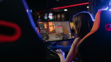 A woman is deeply engaged in playing computer games indoors, highlighting the gaming lifestyle.