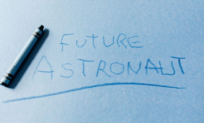 Handwritten text 'Future Astronaut' on blue paper with a crayon.