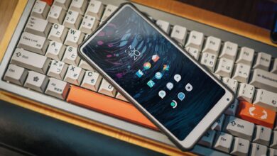 Close-up of a smartphone lying on a vintage mechanical keyboard, showcasing a modern interface.