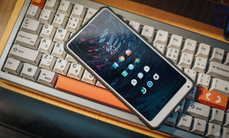 Close-up of a smartphone lying on a vintage mechanical keyboard, showcasing a modern interface.