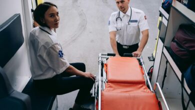 Two paramedics prepare a stretcher inside an ambulance, ready for an emergency response.
